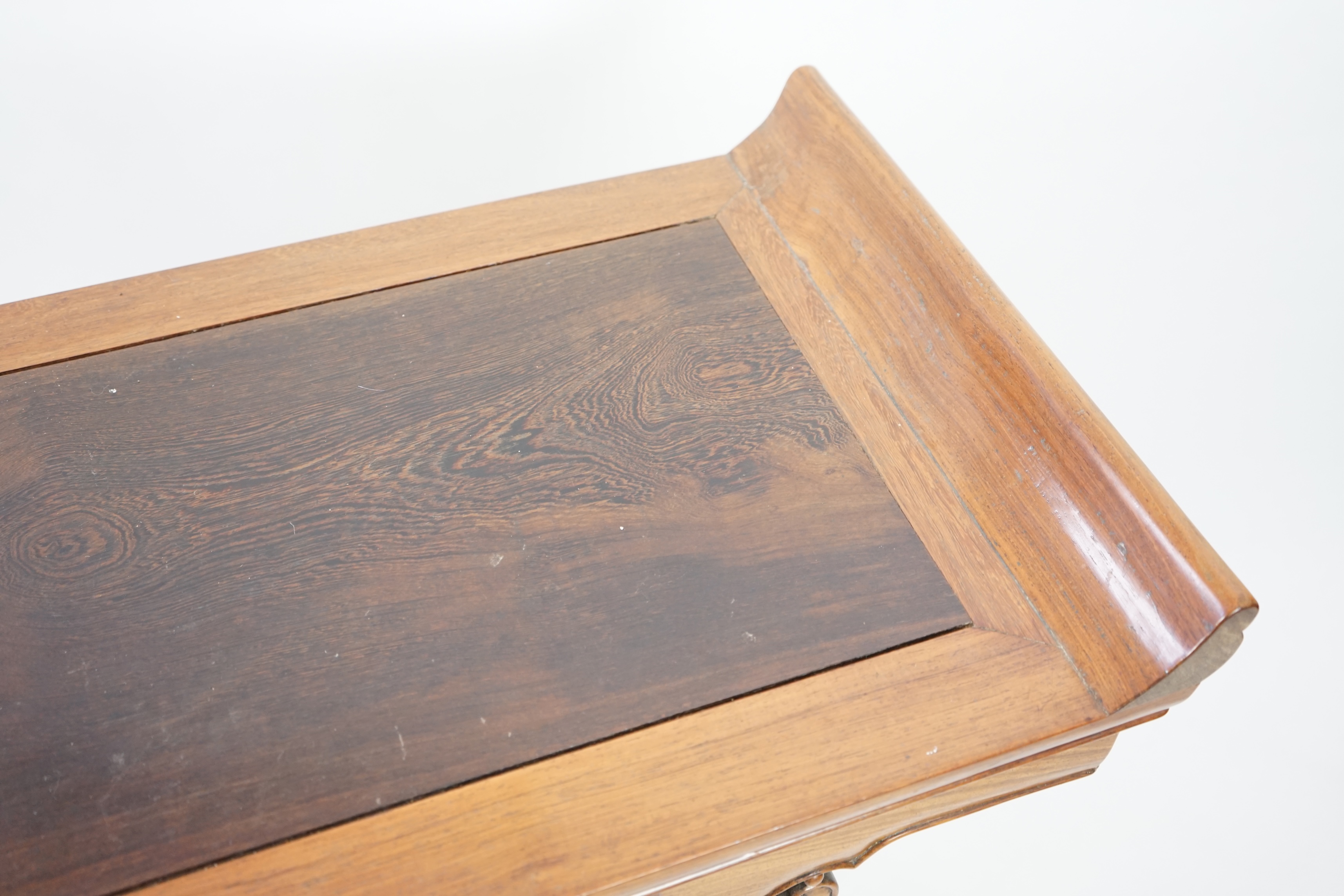 A Chinese padouk wood and jichimu altar table, the panelled rectangular top with scroll ends, on plain uprights headed by ruyi, 185cm wide, 94cm high. Condition - fair to good